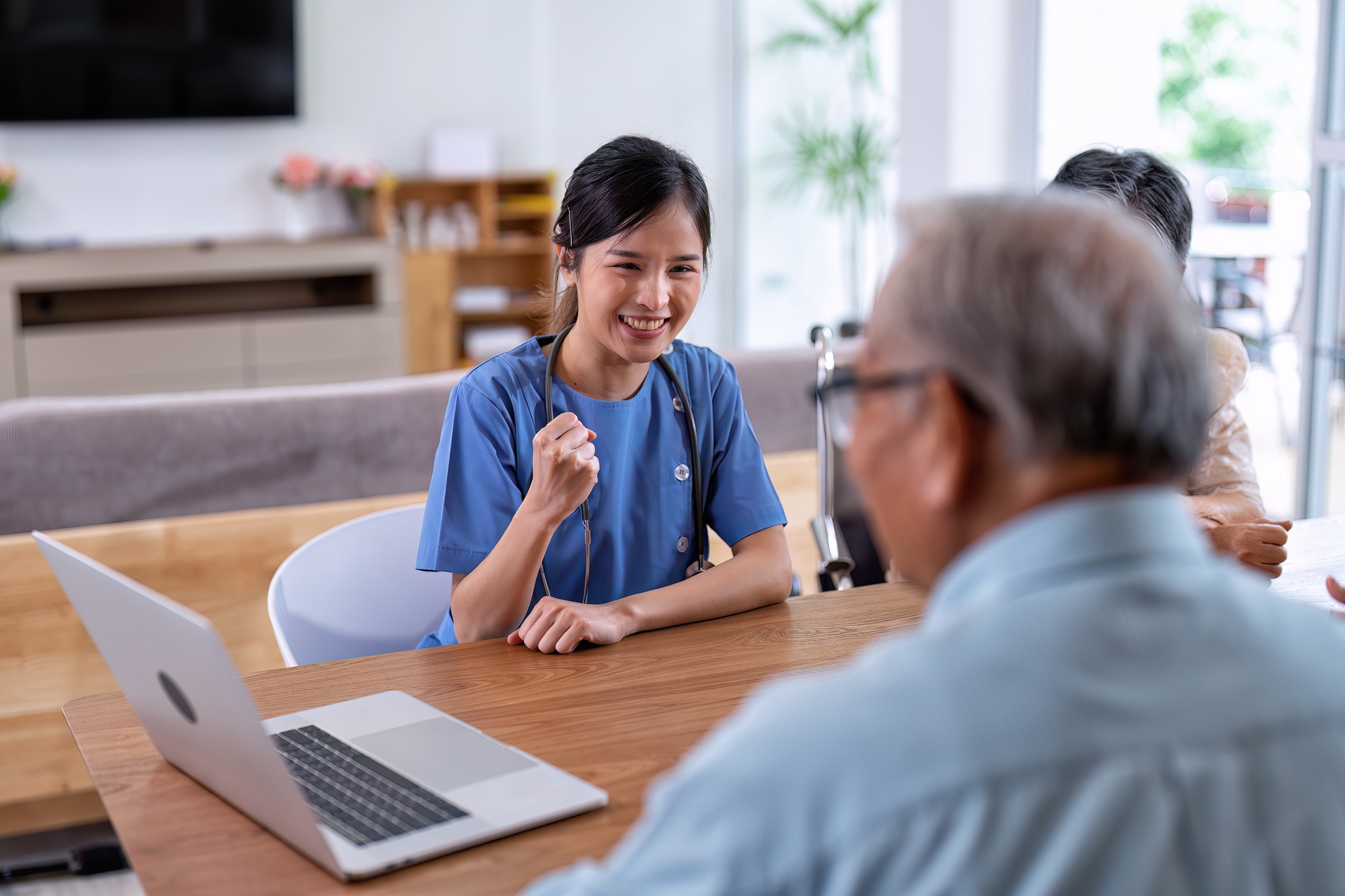 At home care service nurse caregiver take care senior elderly explain healthcare program from laptop